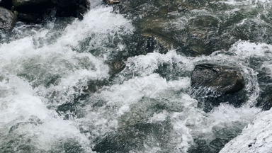 急流河湿巨石狂风暴雨的水流特写镜头泡沫河快速